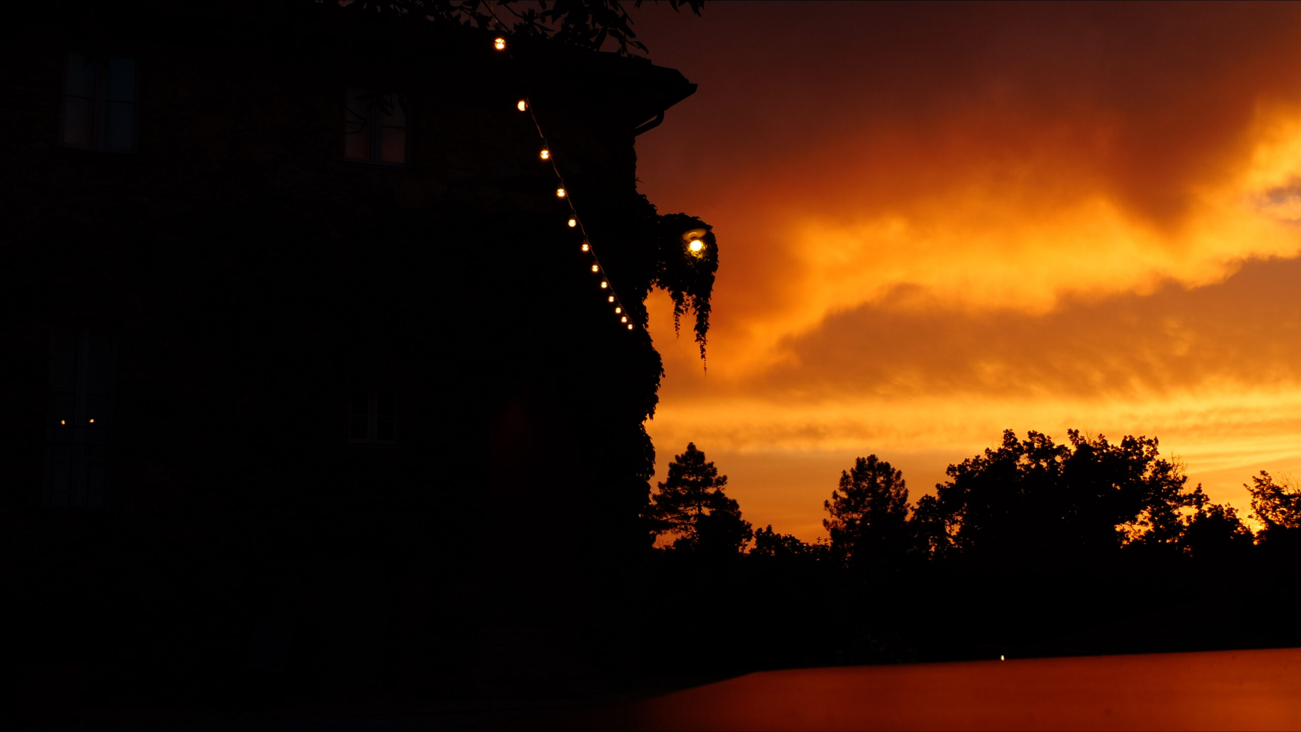 A shot of Villa Podernovo, silhouetted against the sunset in Tuscany, Italy.